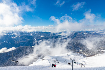 Beautiful snow landscape of snowy trees and ski slope and ski lift of Roza Khutor ski resort. South part of mountains with sunny weather. Sochi, Russia. © umike_foto