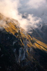 Slope lightened by sun through clouds in Swiss Alps on an autumn day in Switzerland