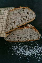 Close up or detailed view of freshly baked sourdough bread, dark background.