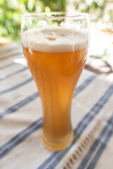 Glass of craft beer with a huge foam