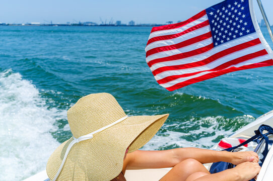 Young woman wearing a hat on a boat cruising the bay in Miami, Florida - Powered by Adobe