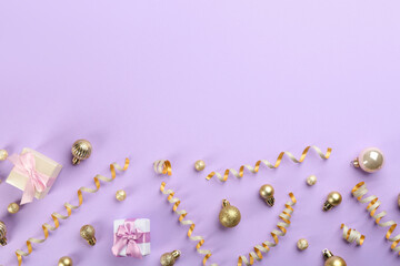 Beautiful serpentine streamers, Christmas balls and gift boxes on violet background, flat lay. Space for text