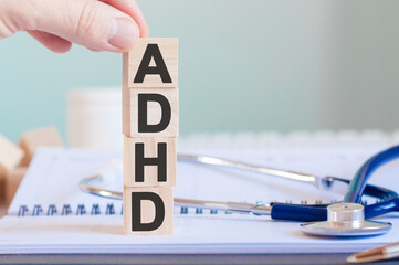 Wooden block form the word ADHD with stethoscope on the doctor's desktop. Medical concept.
