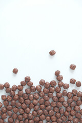Chocolate corn balls scattered on a white background. Top view. Copy, empty space for text