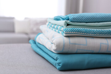 Stack of clean bed linens in room, closeup. Space for text