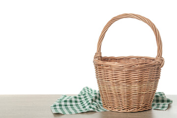 Empty wicker basket and cloth on wooden table against white background, space for text. Easter holiday