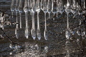 Light reflected through icicles at a river in winter time
