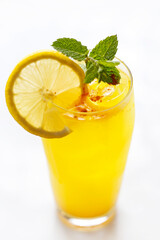 A close-up of glass of lemonade, yellow drink, cocktail isolated on white.