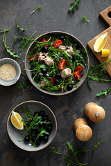 Fresh vegetable salad with tuna, arugula, olives and tomatoes. Healthy food concept, top down view