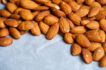 Delicious roasted sweet almonds lie in a large heap, nuts close-up.