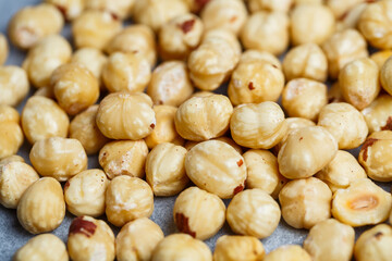 Delicious fried crispy hazelnuts lies in a heap, nuts close-up.