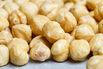 Delicious fried crispy hazelnuts lies in a heap, nuts close-up.