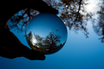 Aeroplane inside a crystal ball with blue sky.