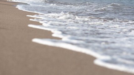 Wave on the beach. The foam of wave on the sand. 