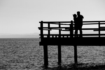 Couple kissing on Old wooden pier on the shore
