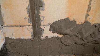 The builders are using triangular steel to smooth the plaster evenly in the walls of the house. concepts of the construction industry with skilled workers. The craftsman evens the putty on the wall.