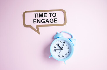 Text Time to engage on pink chalkboard near alarm clock