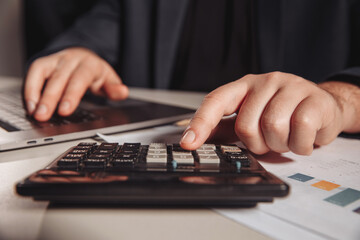 Man working in office using calculator. Business concept. Close-up.