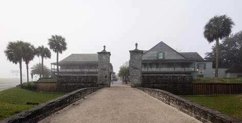 Fototapeta na wymiar Old city gates at the north end of St. George Street in St. Augustine, FL. Constructed 1808. Morning lit through fog looking south.