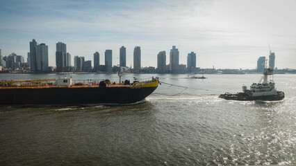 Naklejka premium A barge is being towed on the East River, New York City.