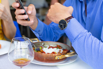 Close up man using smartphone while having lunch