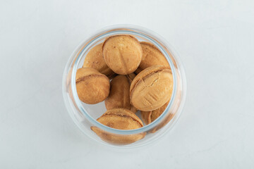 A glass jar full of sweet walnut shaped cookies