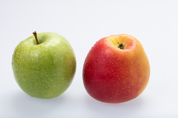 Green and red apples with water drops, isolated on white background