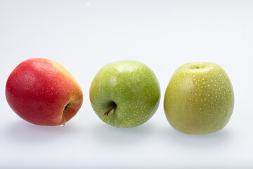 Green and red apples with water drops, isolated on white background