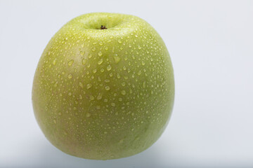 Green apple with water drops, isolated on white background