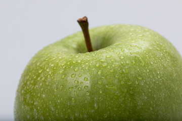 Green apple with water drops, isolated on white background
