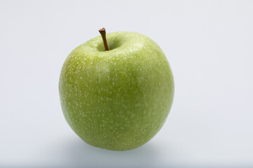 Green apple with water drops, isolated on white background