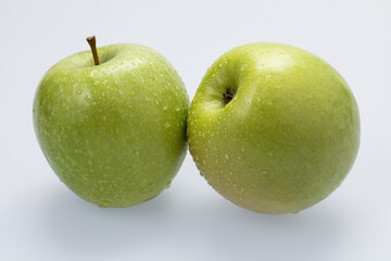 Green apples with water drops on white background