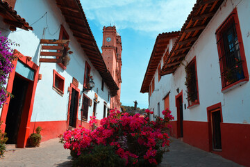 Fototapeta na wymiar Hermosa calle con casas tradicionales en pueblo mágico de Tapalpa, al fondo su catedral