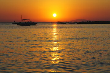 Fototapeta na wymiar Shiny sun ball above sea horizon in beautiful summer evening
