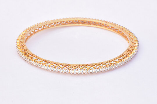 GOLD DESIGNER BANGLE EMBEDDED WITH DIAMOND ON WHITE BACKGROUND