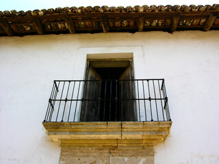 Balcón de casa rustica en pueblo con puerta acero y cantera