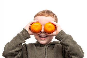 Fototapeta na wymiar Funny red haired boy with oranges on eyes. Dressed green hoodie. isolated on white.