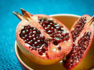 Red juicy pomegranate fruit cut in half. Fresh ripe pomegranates. Healthy food theme. Two halves of...