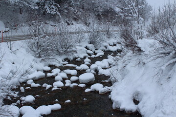 Snow-covered rocks inside the river 