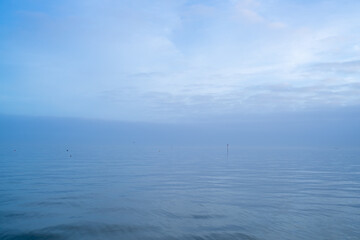Cloudy blue minimalist seascape. Deserted space with horizon line. 
