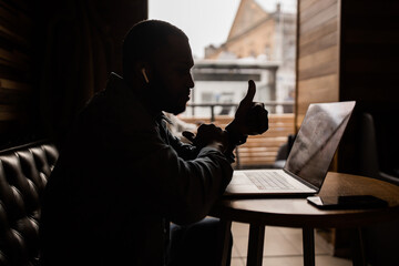 Contented African American business man showing thumb up. Leads an online consultation, an excited businessman looks at a laptop screen, a positive customer recommending service, good quality.