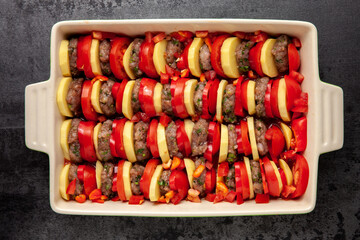 Raw uncooked ready to bake kafta of slices of meatballs, potatoes, tomatoes and peppers....