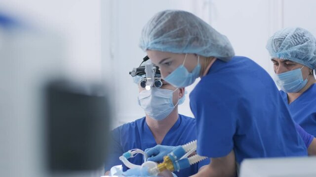 The anesthesiologist with assistants prepares female patient for surgery, puts patient into anesthesia, regulates oxygen mask, endotracheal tube. Surgery. Anesthesia
