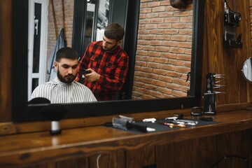 Barber shop. Man with wife in barber's chair, hairdresser Barbershop styling his hair