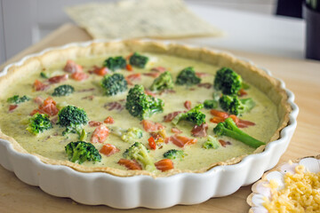 The process of making a quiche fish pie. Shortcrust pastry crust with pieces of red fish in it. Close-up. Fish pie recipe. Salmon pie recipe