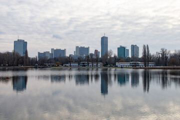 Fototapeta na wymiar Skyline of VIC (UNO city) in Vienna, Austria as seen from across Alte Donau (Old Danube) in winter, with reflections of the buildings on the water.