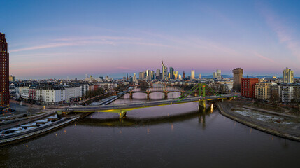 Naklejka premium Aerial panoramic picture of Frankfurt skyline with river Main with colorful sky during sunrise