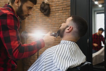 Young Bearded Man Getting Beard Haircut By Barber. Barbershop Theme