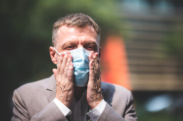 professional adult businessman wearing surgical face mask to protect of coronavirus covid-19,...