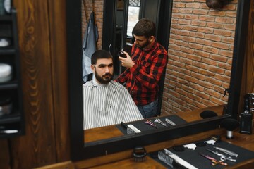 Serious Young Bearded Man Getting Haircut By Barber. Barbershop Theme